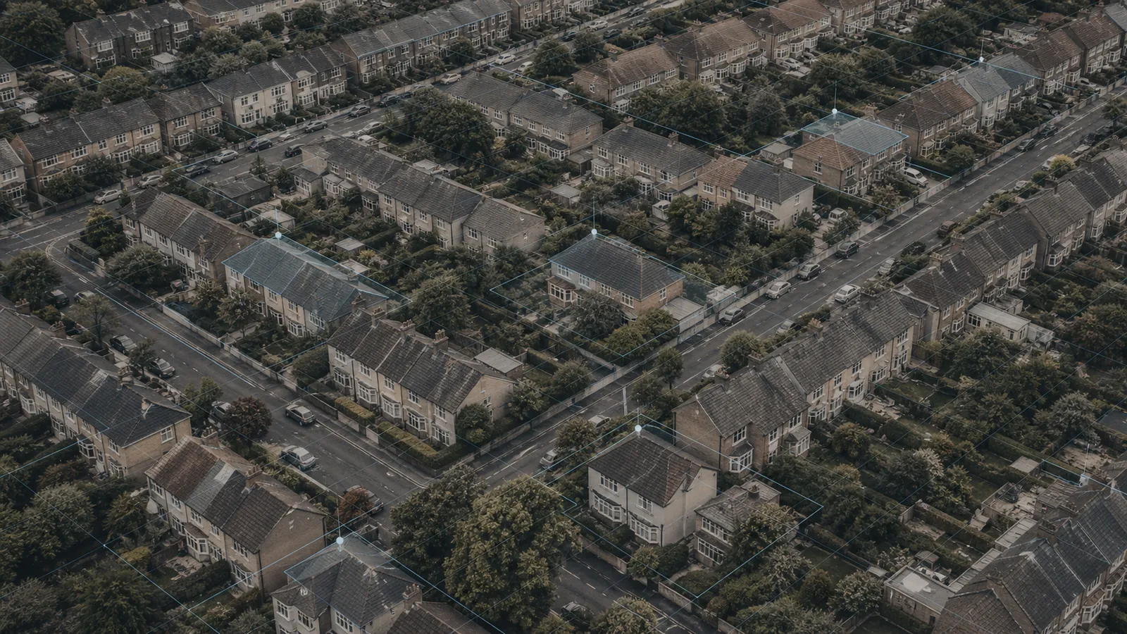 Aerial view of English suburban streets with fine survey lines drawn across the rooftops